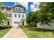 Townhouse with neutral vinyl siding, a one-car garage and well-maintained lawn, with shrubbery and a young tree at 2932 Pirates Pl, Charlotte, NC 28216