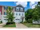 Townhouse with neutral vinyl siding, a one-car garage and well-maintained lawn with shrubbery and a young tree at 2932 Pirates Pl, Charlotte, NC 28216