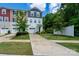 Townhouse with neutral vinyl siding, a one-car garage and well-maintained lawn with shrubbery and a young tree at 2932 Pirates Pl, Charlotte, NC 28216