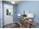 Welcoming blue foyer with decorative table and lamps, leading to the front door at 2932 Pirates Pl, Charlotte, NC 28216
