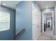 Hallway with blue wall, stairs, window, and open doorway to a carpeted room at 2932 Pirates Pl, Charlotte, NC 28216