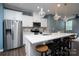 Bright kitchen with a stainless steel refrigerator, a white island, white cabinets, and pendant lighting at 2932 Pirates Pl, Charlotte, NC 28216