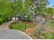 Exterior shot of a beautiful home with lush greenery, a circular driveway, and mature trees enhancing its curb appeal at 3005 Kenninghall Ct, Charlotte, NC 28269