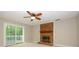 Cozy living room features a brick fireplace, ceiling fan, and sliding glass doors to the deck at 3005 Kenninghall Ct, Charlotte, NC 28269