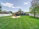 Lush backyard with patio, fire pit, and well-manicured lawn, offering a serene outdoor living space at 3530 Farm Lake Sw Dr, Concord, NC 28027