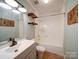 Bathroom offering a shower-tub combo, floating wood shelves, tiled floors, and a vanity sink at 3530 Farm Lake Sw Dr, Concord, NC 28027