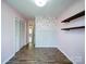 Bedroom showcasing wood floors, bi-fold door closet, decorative wall trim and hanging shelves at 3530 Farm Lake Sw Dr, Concord, NC 28027