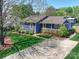 Charming single-story home with a covered front porch, well-manicured lawn, and mature trees offering shade at 3530 Farm Lake Sw Dr, Concord, NC 28027