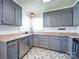 Updated kitchen featuring stainless steel appliances, grey cabinets, and unique, patterned flooring at 3530 Farm Lake Sw Dr, Concord, NC 28027