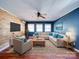 Bright living room with blue accent wall, ceiling fan, wood floors and large sectional at 3530 Farm Lake Sw Dr, Concord, NC 28027