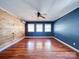 Bright living room with blue accent wall, ceiling fan, and wood floors at 3530 Farm Lake Sw Dr, Concord, NC 28027