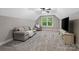 This bonus room has a couch, chair, television, carpet, and a window to the backyard at 358 Grassy Ridge Ct, Clover, SC 29710