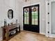 Elegant entryway with a rustic wooden table, decorative mirror, and stylish double doors at 358 Grassy Ridge Ct, Clover, SC 29710