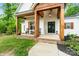 Close-up of a cozy front porch with wooden columns and black rocking chairs at 358 Grassy Ridge Ct, Clover, SC 29710