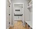 Hallway view of a laundry room with dark countertops and white cabinets, with built-in storage and bench at 358 Grassy Ridge Ct, Clover, SC 29710