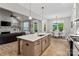 Modern kitchen featuring an island with a sink, stainless appliances, and an adjacent breakfast nook with natural light at 358 Grassy Ridge Ct, Clover, SC 29710