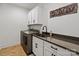 Laundry room with modern washer and dryer, dark countertops, white cabinets and laminate flooring at 358 Grassy Ridge Ct, Clover, SC 29710