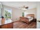 A cozy bedroom showcases a wooden bed frame, hardwood floors, two windows, and a wooden dresser at 3849 Carl Parmer Dr, Harrisburg, NC 28075