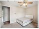 A simple bedroom shows a bed, carpeted floors, ceiling fan and open doorway at 3849 Carl Parmer Dr, Harrisburg, NC 28075