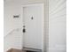 Clean white apartment door with visible unit number and accessible railing at 3849 Carl Parmer Dr, Harrisburg, NC 28075