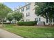 A three-story apartment building with blue shutters and lush green lawn and landscaping under a bright blue sky at 3849 Carl Parmer Dr, Harrisburg, NC 28075