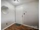 Neutral-toned foyer with wood-look flooring, a white door, and a round mirror at 3849 Carl Parmer Dr, Harrisburg, NC 28075