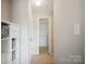 Bright hallway with convenient closet, shelving, and neutral carpet at 3849 Carl Parmer Dr, Harrisburg, NC 28075