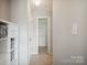 Well-lit hallway with shelving, carpet, closet, and neutral paint at 3849 Carl Parmer Dr, Harrisburg, NC 28075