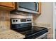 Stainless steel oven and granite countertops featured in this well-lit kitchen at 3849 Carl Parmer Dr, Harrisburg, NC 28075