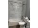 Close up of tiled tub/shower combo with gray accent walls and chrome fixtures in bathroom at 402 California St, York, SC 29745