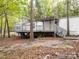 View of the large gray back deck and stairs, surrounded by mature trees and stone steps leading to the house at 4757 Mountain View Ln, Maiden, NC 28650