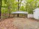 Exterior view of the white carport, with a partial view of the house, on a treed lot with lots of trees at 4757 Mountain View Ln, Maiden, NC 28650