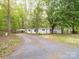 Exterior shot of the house and driveway, on a treed lot with lots of trees, with a carport at 4757 Mountain View Ln, Maiden, NC 28650