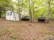 Exterior view of the house and outbuilding, on a treed lot with green grass, fallen leaves and vegetation at 4757 Mountain View Ln, Maiden, NC 28650
