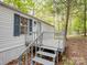 Quaint home entrance with gray deck and stairs, complemented by light-colored siding and dark blue shutters at 4757 Mountain View Ln, Maiden, NC 28650