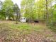 Exterior view of the house and the back yard, on a treed lot with green grass and lots of trees at 4757 Mountain View Ln, Maiden, NC 28650