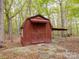 View of the rustic barn-style outbuilding, featuring stone steps, corrugated metal roof, and double doors at 4757 Mountain View Ln, Maiden, NC 28650