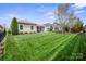 Well-maintained backyard with lush green grass, landscaping, and a patio area perfect for outdoor entertaining at 4831 Looking Glass Trl, Denver, NC 28037