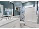 Modern bathroom with a stylish vanity, mirror, and shower with blue patterned curtain at 4831 Looking Glass Trl, Denver, NC 28037