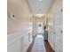 Inviting hallway with hardwood floors, wainscoting, and a view to the foyer at 4831 Looking Glass Trl, Denver, NC 28037