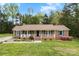 Charming brick ranch with inviting front porch and beautifully landscaped yard in a serene, wooded setting at 504 Ogden Dr, Gastonia, NC 28056