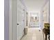 Bright hallway with white tile flooring leading to a bathroom vanity with double sinks and white cabinetry at 504 Ogden Dr, Gastonia, NC 28056
