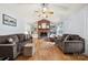 Cozy living room with hardwood floors, a brick fireplace, built-in shelves, and comfortable brown couches at 504 Ogden Dr, Gastonia, NC 28056