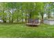 Expansive backyard with lush lawn, mature trees, a trampoline, and storage shed at 5211 Driftwood Dr, Davidson, NC 28036