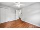 Bedroom with hardwood floors, a ceiling fan, and a closet with paneled doors at 5211 Driftwood Dr, Davidson, NC 28036