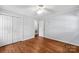 Bedroom with hardwood floors, ceiling fan, and closet with paneled doors at 5211 Driftwood Dr, Davidson, NC 28036