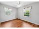 Bedroom featuring hardwood floors and two windows with star-themed curtains at 5211 Driftwood Dr, Davidson, NC 28036