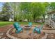 Outdoor fire pit with stone surround and Adirondack chairs in landscaped backyard at 5211 Driftwood Dr, Davidson, NC 28036