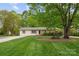 Landscaped front yard featuring a mature tree, trimmed lawn, and charming curb appeal at 5211 Driftwood Dr, Davidson, NC 28036