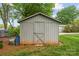 Exterior view of a weathered, grey storage shed with a simple, pitched roof at 5211 Driftwood Dr, Davidson, NC 28036
